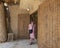 Female Korean tourist shopping at a business on a street leading to an entrance to the Shali Fortress remains in Siwa, Egypt.