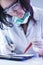 Female Laboratory Worker Dealing With Flask Containing Liquid Chemicals Using Protective Gloves