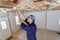 Female labourer working on wooden ceiling joists