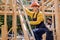 Female on ladder,goes up to the roof, in uniform, with man working in the background