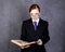 Female lawyer reads a big book with serious expression, woman in a man`s suit, tie and glasses