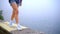 Female legs on beach sea. Woman feet walking on border sea