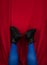 Female legs in blue tights black boots upside down on red background. Fashion modern style. Vivid contrasting colors
