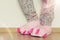 Female legs in cute pink monster foot slippers