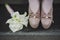 Female legs in fashion brown shoes and white beautiful bouquet of white flowers