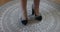 Female legs and feet of a standing adult woman modeling high heels with brown tiger prin