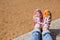 female legs in jeans and a bright floral sneakers in the background of the sand in the summer