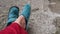 Female legs in old worn slippers on cement background, concept of poverty, indifference, altruism