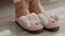 Female legs putting on cozy rabbit plush home slippers and walking away