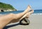 Female legs resting on coconut tropical beach