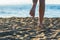 Female legs on the sand on a sunset background. ConceptFemale legs on the sand on a sunset background.