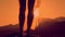 Female legs silhouette, sunset mountain background