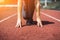 Female Legs in sneakers close-up on pink athletic track