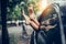 Female legs stick out of the car window. Woman having fun and relaxing in a car during road trip.