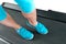 Female legs in turquoise sneakers on a treadmill.