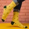 Female legs in yellow socks with drawings of lemon, on a yellow surface, concept