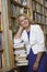 Female Librarian Standing By Stack Of Books