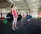 Female Lifting Barbells With Friends In Gym