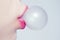 Female lips blowing pink bubble gum. Closeup of a woman face with pink lips and gum bubble. emale lips holding shiny