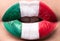 Female lips close up with a picture flag of Italy. Green, white, red.