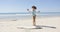 Female listening music and dancing on beach