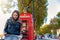 Female London tourist looks at a map in front of a red telephone booth