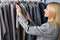 Female looking at new collection of stylish clothes on hangers clothing rack rails