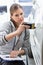 Female maintenance engineer checking car paint with equipment in workshop