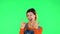 Female making a rock gesture, enjoying life and laughing. Green screen