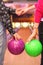 Female and male hands with balls in bowling club