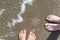 Female and male legs with huge sparkling snowflake on the sand in the sea foam.