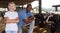 Female and male proffesional farmers standing near cow at farm