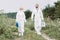 female and male scientists in protective suits walking with working suitcase and clipboard
