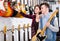 Female and male teenagers examining electric guitars