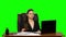 Female manager works on a laptop, think and takes notes. Green screen background