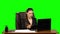 Female manager works on a laptop, think, takes notes then smile with happy. Green screen background