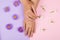 Female manicure background. Hand and nail care. Beautiful young woman`s hands on pink and purple background with flowers. Hand wi