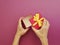 Female manicure hands hold romance a gift box surprise , on a colored background