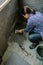 Female mason laying a new tile floor