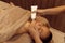 Female masseur applies cream on woman`s face