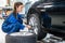 Female Mechanic Changing Car Tire At Automobile Shop