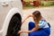 Female mechanic changing tire with wheel wrench