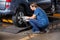 Female Mechanic Fixing Car Tire With Pneumatic Wrench