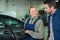 Female mechanic with male customer going through maintenance car