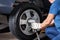 Female Mechanic Using Pneumatic Wrench To Fix Car