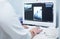 A female medical doctor looking at x-rays and using laptop in a hospital