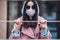 Female in medical mask outdoors behind the gate. Health protection and prevention of virus, coronavirus, COVID-19, epidemic and