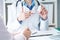 Female medicine doctor hand hold jar of pills second hand points to the medicine.Young doctor talks to patient about the