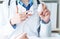 Female medicine doctor hand hold jar of pills second hand points to the medicine.Young doctor talks to patient about the