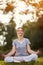 Female meditate in green park